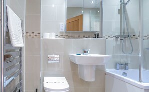 Ein modernes Badezimmer mit Toilette, Waschbecken und Dusche.