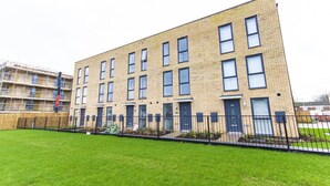 Un immeuble résidentiel à plusieurs étages, doté d’une façade en briques, de nombreuses fenêtres et d’une pelouse bien entretenue à l’avant.