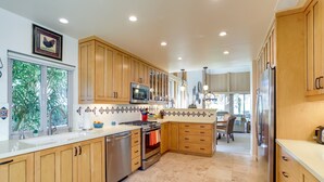 A modern kitchen with wooden cabinets, stainless steel appliances, and a tiled backsplash. - PGA West Mtn Course: Luxury Golf Retreat! (La Quinta)