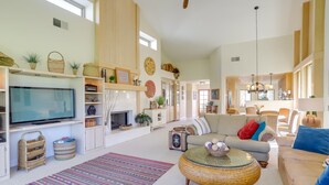 A spacious living room with a television, sofas, a coffee table, and a fireplace. - PGA West Mtn Course: Luxury Golf Retreat! (La Quinta)