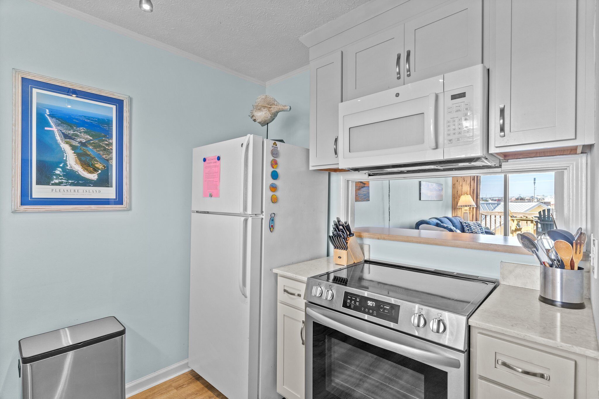 A modern kitchen with white cabinets, a stainless steel stove, and a refrigerator.