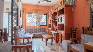 A living room with a sofa, chairs, a coffee table, and wooden cabinets. - Capital O Hotel Aurora, Tuxtla Gutiérrez (Tuxtla Gutierrez)