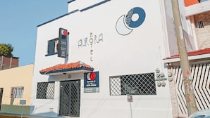 A building with a sign for "Aurora Hotel" and a red circular logo. - Capital O Hotel Aurora, Tuxtla Gutiérrez (Tuxtla Gutierrez)