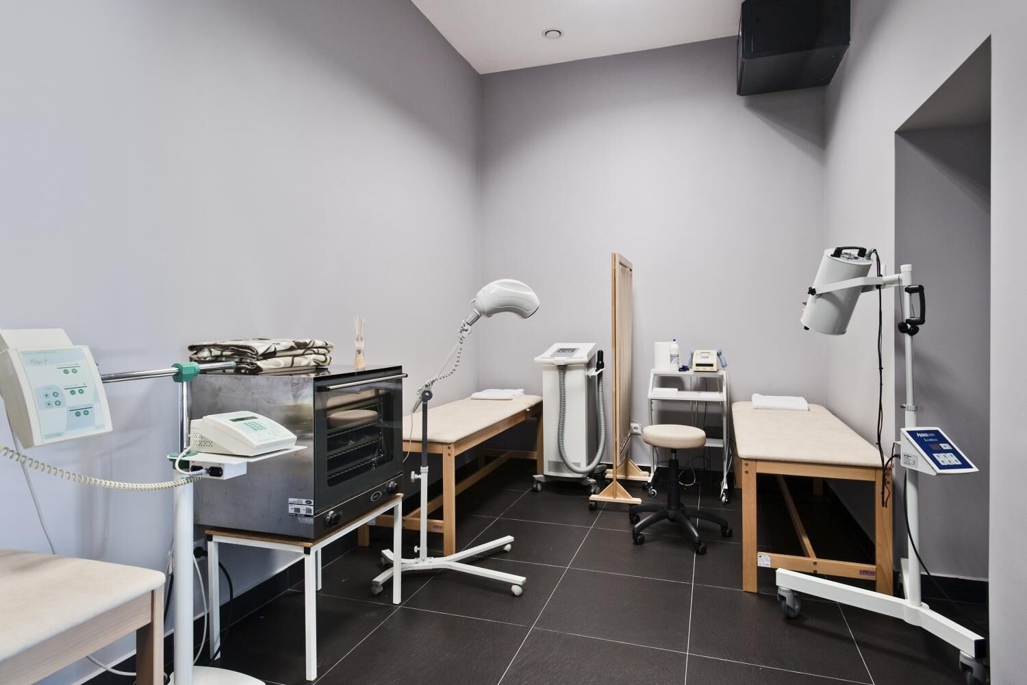 Un ambiente clinico con attrezzature mediche, una scrivania e una sedia.