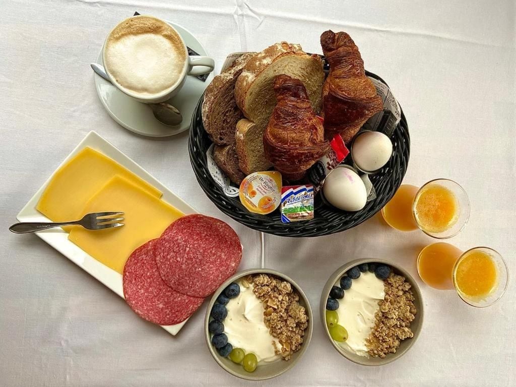 Une table dressée pour le petit-déjeuner avec des croissants, des œufs et une tasse de café.