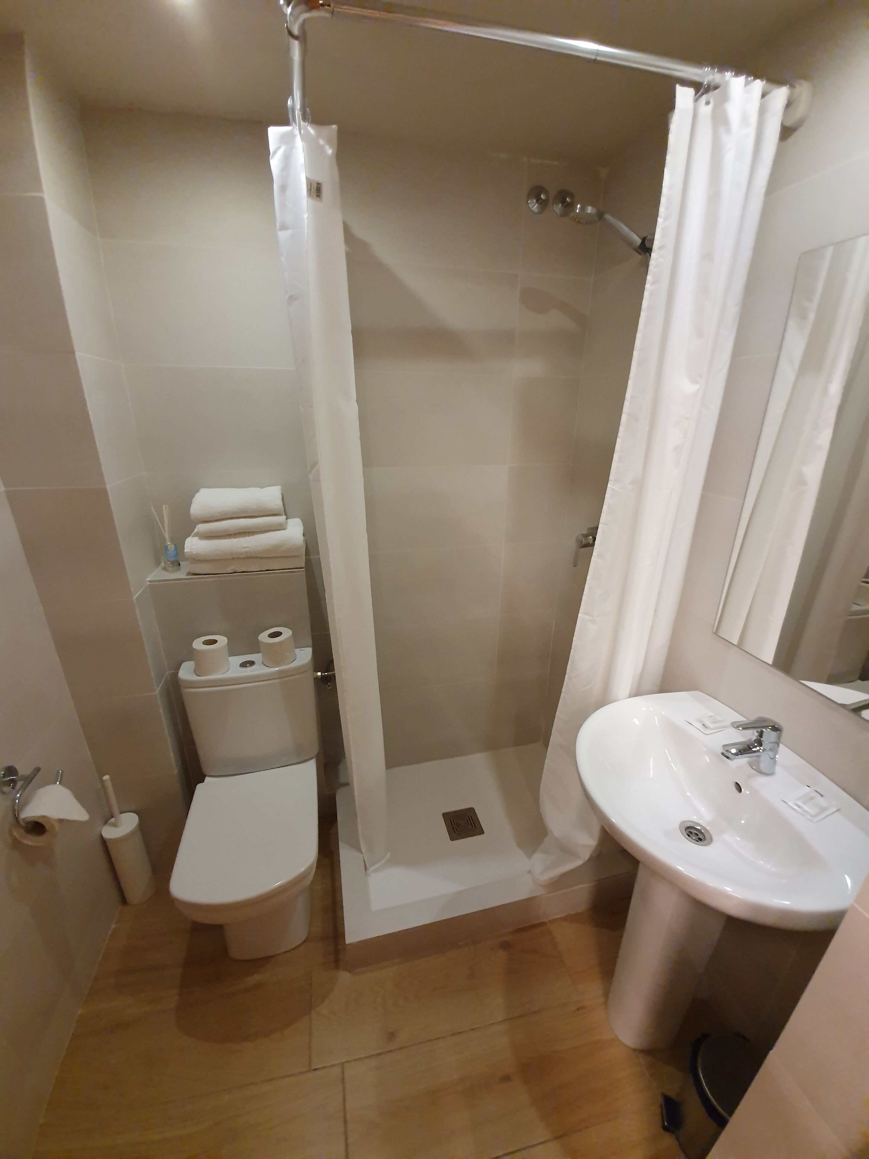 A bathroom with a shower, toilet, and sink.