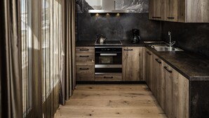 A modern kitchen with wooden cabinets, a stainless steel range hood, and a built-in oven.