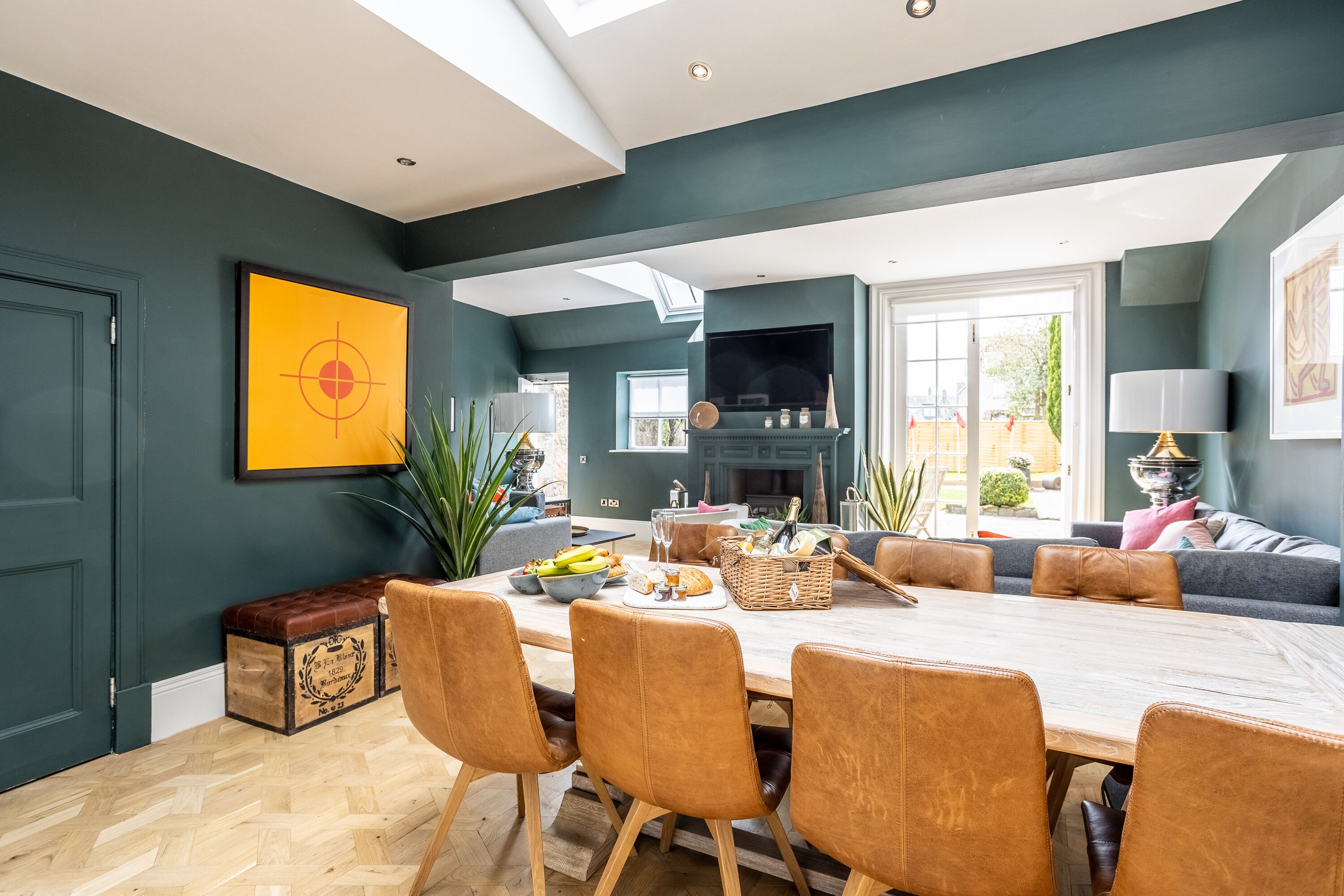 Un área de comedor moderna con una mesa de madera y sillas de cuero, un televisor y una chimenea.