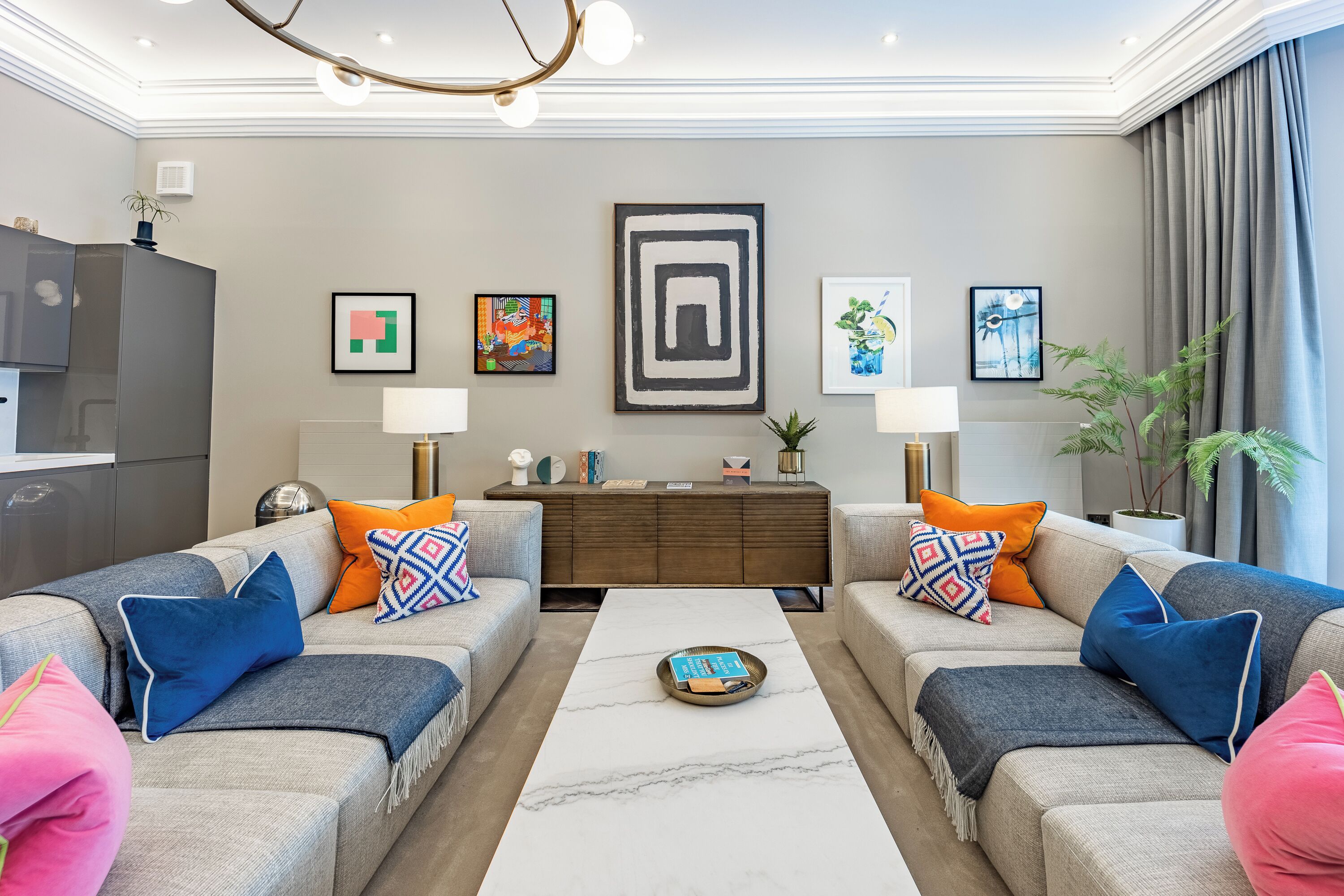 A modern living room with two sofas, a coffee table, and artwork on the walls.