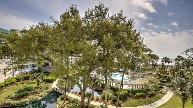 A resort with a swimming pool, palm trees, and a well-maintained garden. - 3305 Windsor Court South -Amazing renovated 3rd Floor Oceanfront Villa (Hilton Head Island)