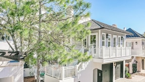 Ein zweistöckiges Haus mit Balkon, Garage und überdachter Auffahrt.