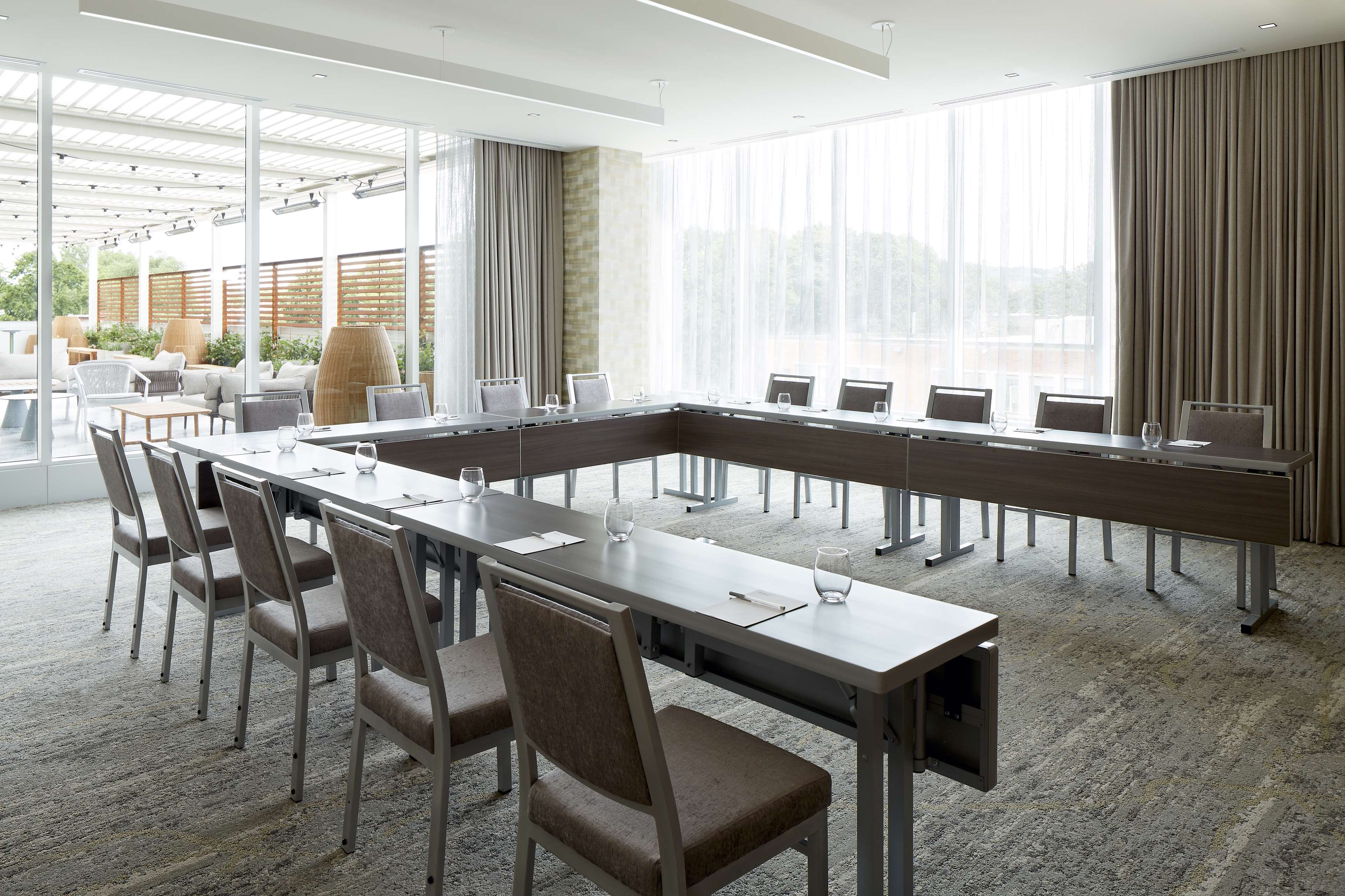 A conference room with a long table, chairs, and large windows.