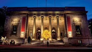 The exterior of The Montreal Museum of Fine Arts at night, featuring classical architecture with columns and a large illuminated sculpture in front. - Hilton Garden Inn Montreal Midtown (Montreal)