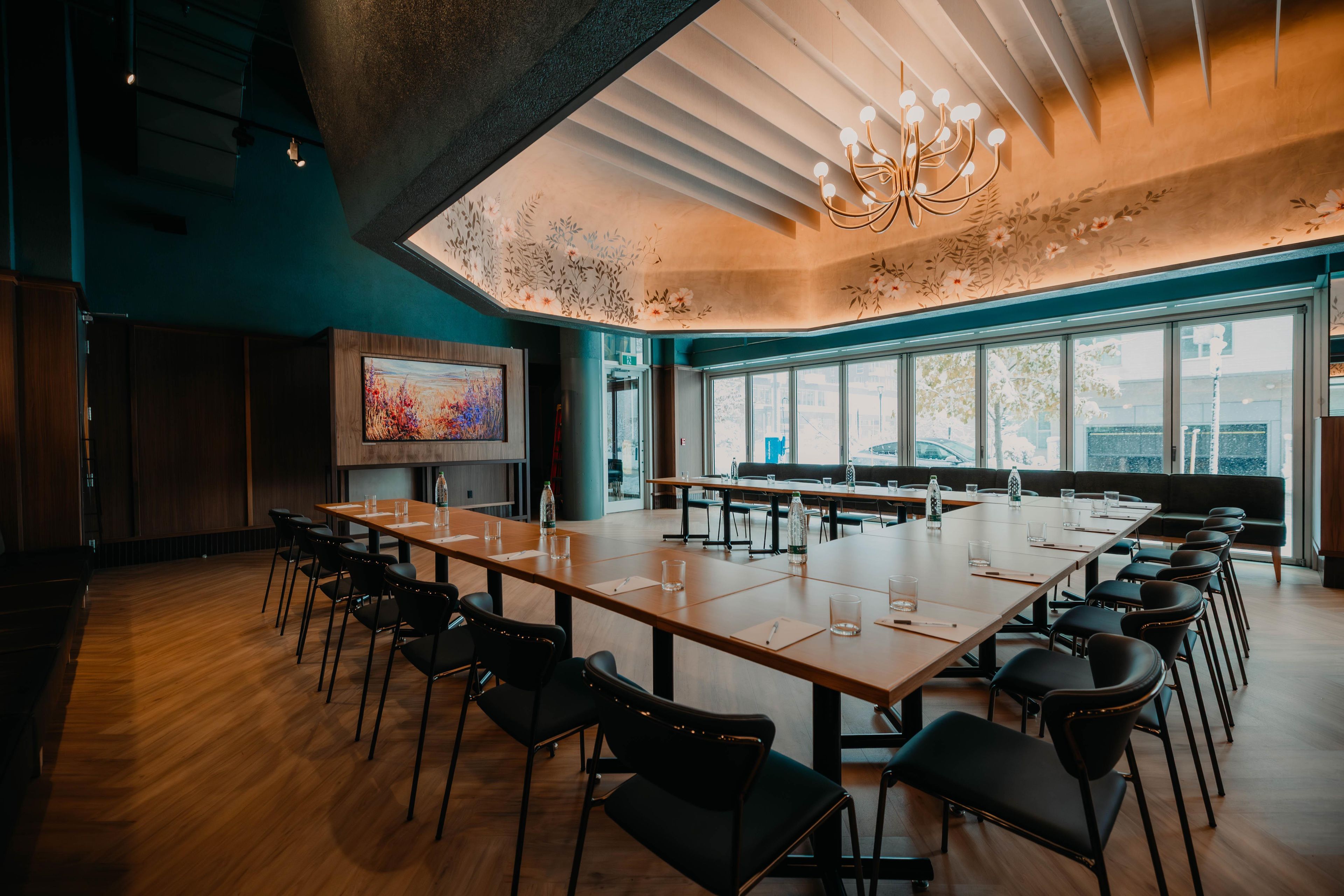 A conference room with a long table, chairs, and a large window.