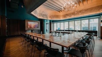 A conference room with a long table, chairs, and a large window.