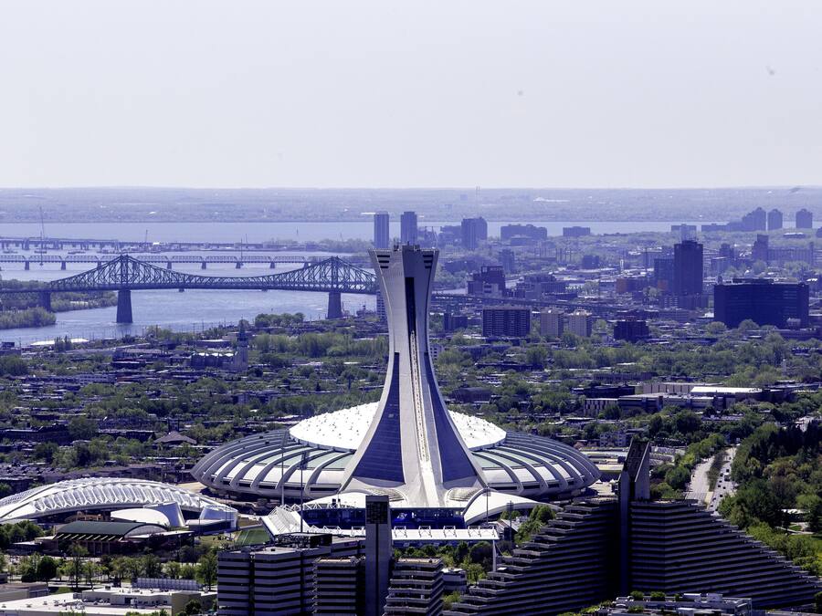 Uma estrutura arquitetônica moderna com uma torre central e edifícios ao redor, provavelmente um hotel ou centro de convenções.