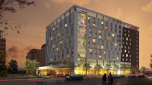 A modern hotel with a large glass facade, multiple floors, and a prominent entrance with a covered area. - Hilton Garden Inn Montreal Midtown (Montreal)