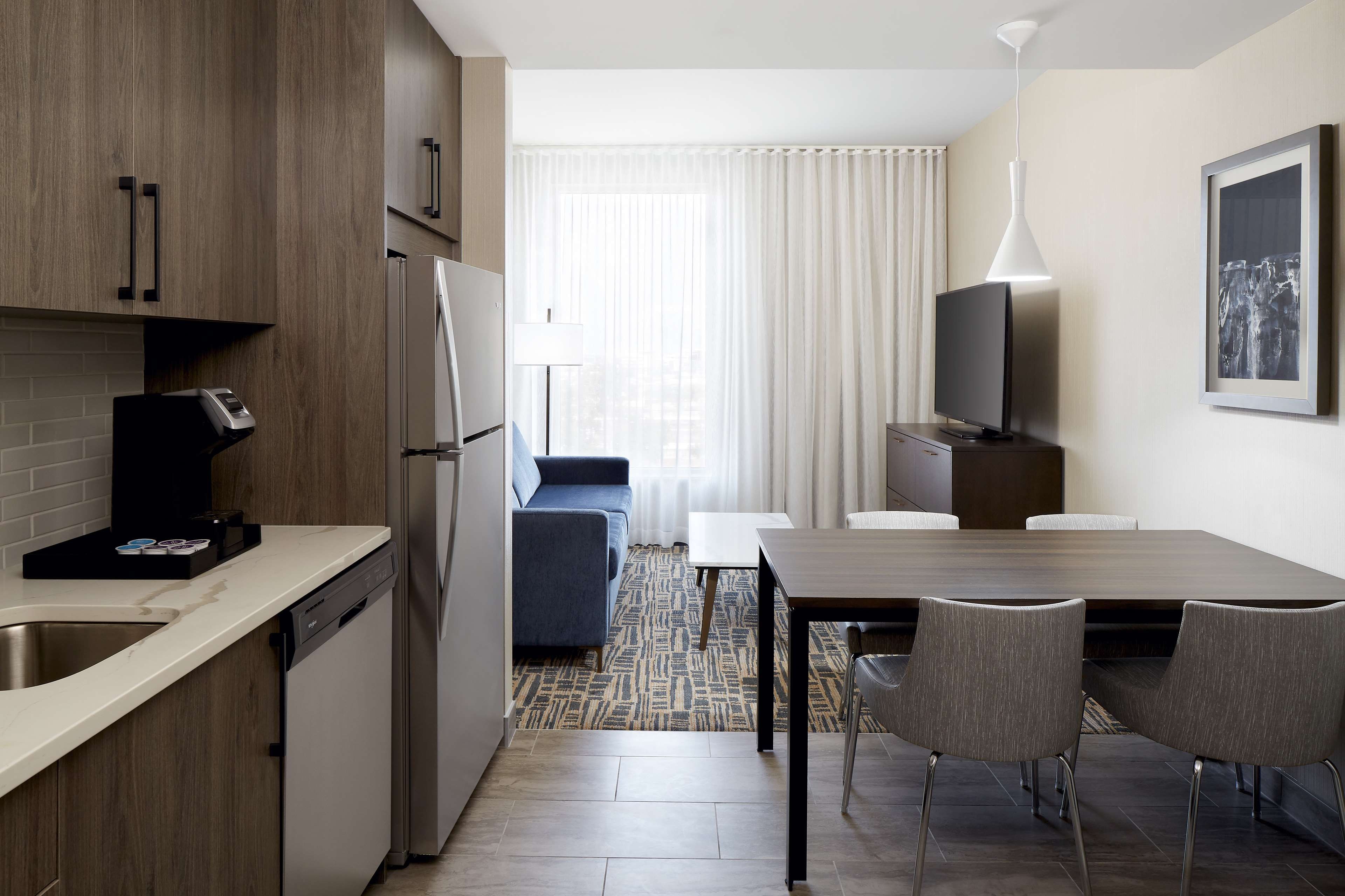 Une chambre d’hôtel compacte comprenant un coin cuisine, un espace repas et un coin salon.