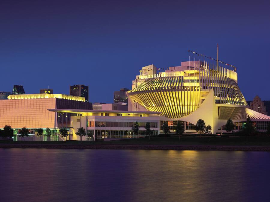 A modern building with a unique curved roof and multiple flagpoles.