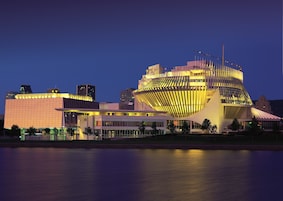 Un edificio moderno con un techo curvo distintivo y varias antenas de pabellón.