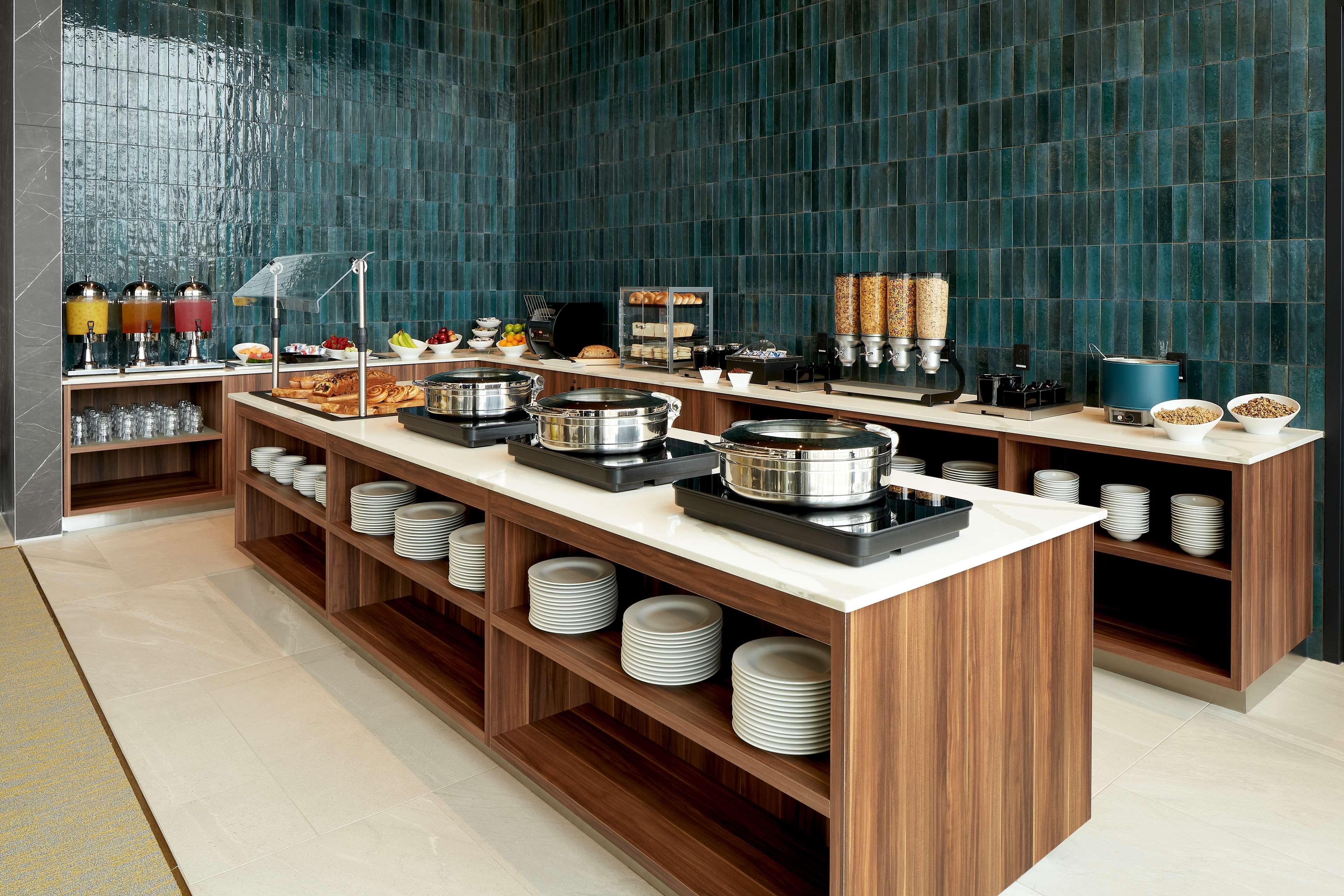 A buffet setup with multiple serving stations, including hot and cold food options, and a variety of condiments and beverages.