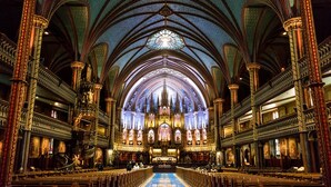 L’intérieur d’une cathédrale, avec une nef centrale, des voûtes en arc et des colonnes richement décorées.