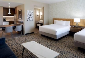 Ein Hotelzimmer mit Bett, Nachttisch, Lampe und einem kleinen Schreibtisch mit Stuhl.