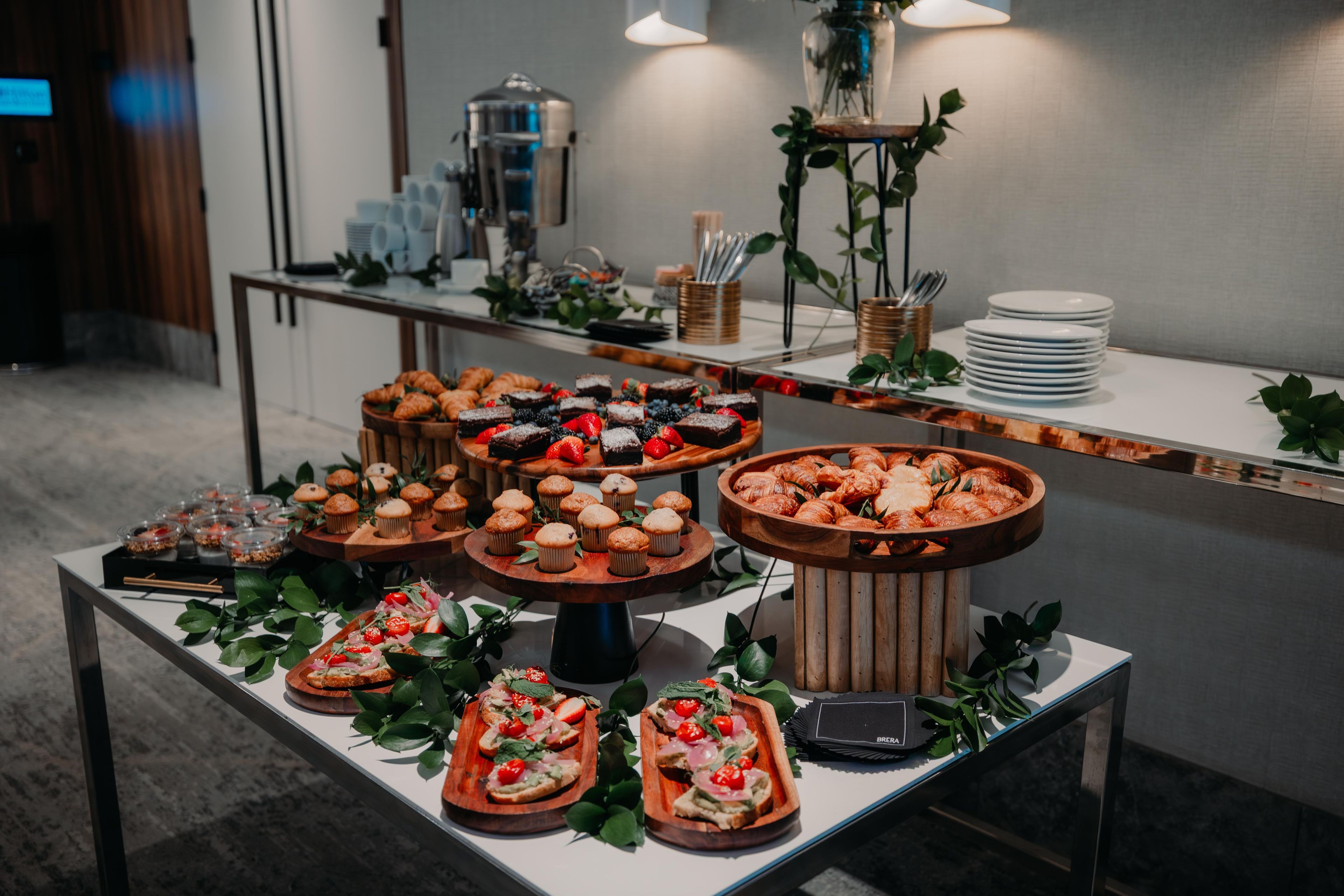 A buffet table with various food items and a coffee machine.