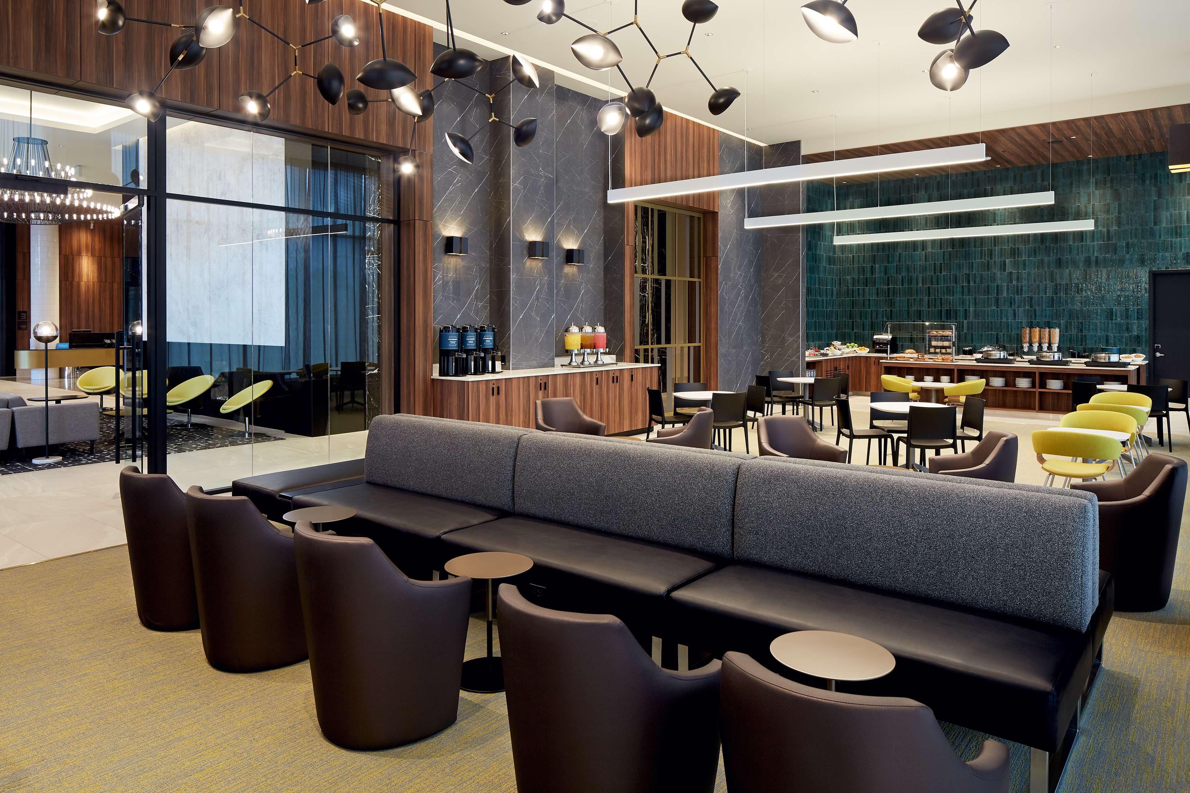 Un área de descanso moderna con sofá, sillones y estación de café.