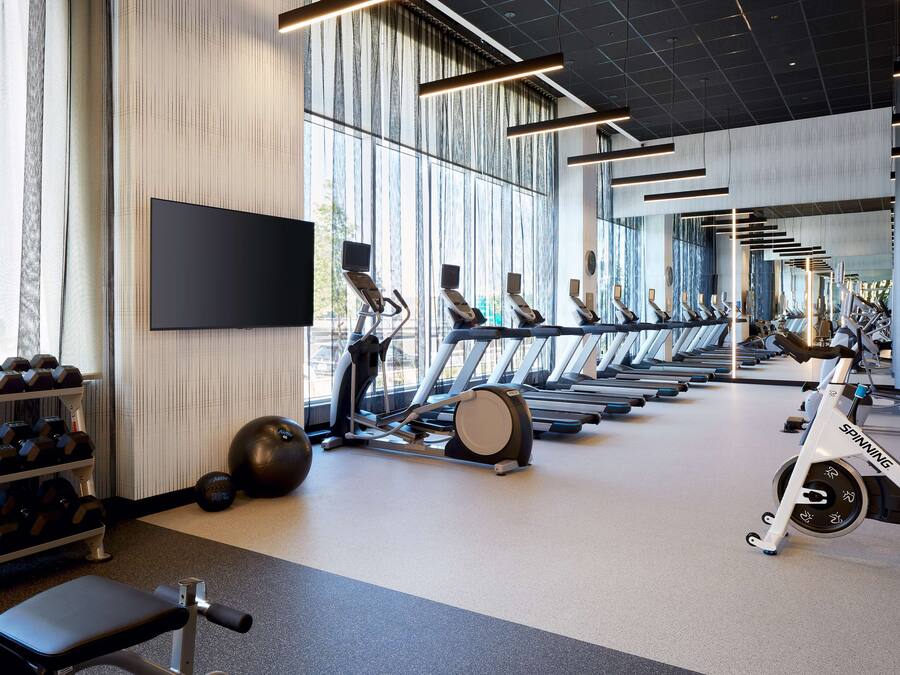 Ett gym med löpband, träningsbollar och hantlar.