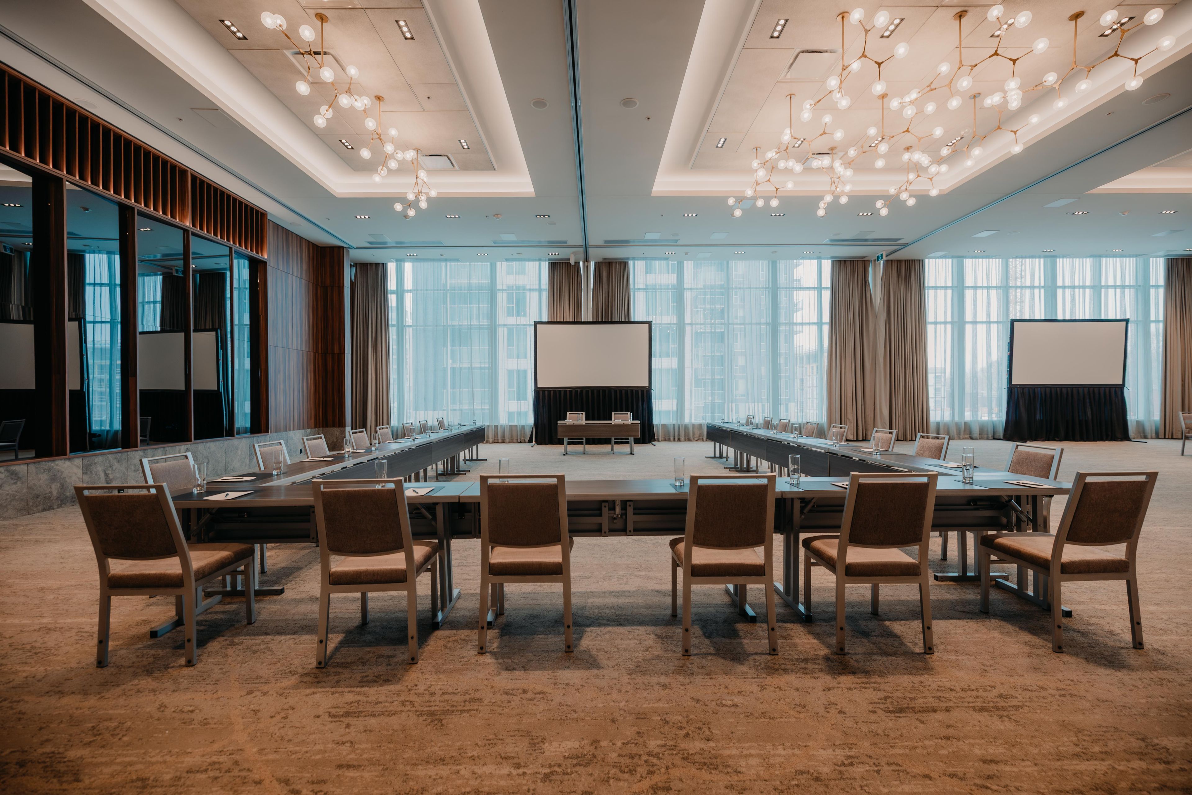 Une salle de conférence avec une longue table, des chaises et un grand écran.
