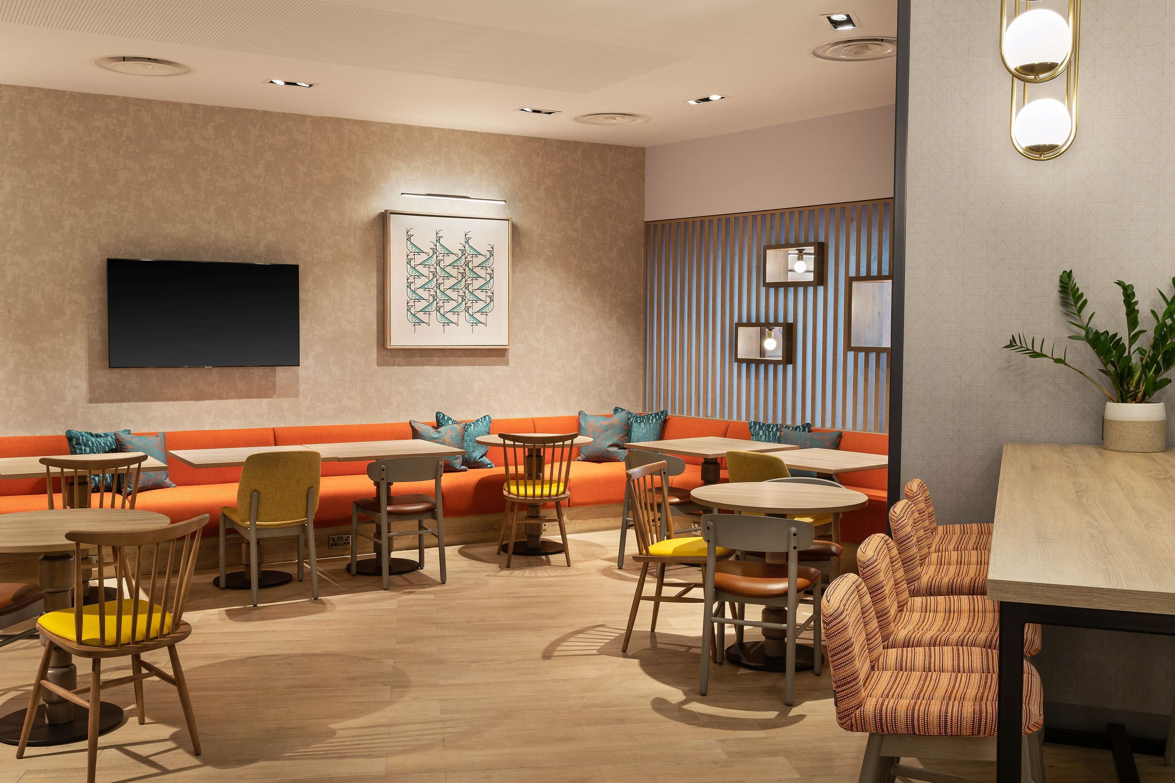 A modern interior with a sofa, chairs, tables, and a flat-screen TV.