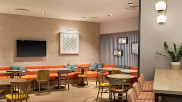 A modern interior with a sofa, chairs, tables, and a flat-screen TV.