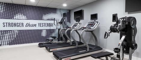 A gym with treadmills, a stationary bike, and a weight machine.