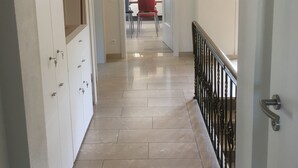 A hallway with a tiled floor, a red chair, and a white cabinet with keys hanging on it. - Newly renovated (in 2020) vacation apartment, 4 p., with a great view of the Moselle valley (Briedern)