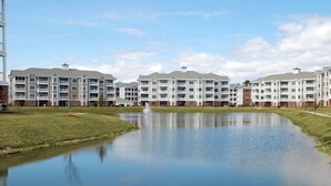 A multi-story residential building with a central courtyard and a reflective water feature. - Magnolia Place by Palmetto Vacations (Myrtle Beach)