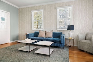 A living room with a blue sofa, two side tables, and a lamp. - Charming Ground Floor Suite 6 Blocks To King (Charleston)