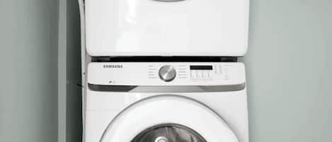 A Samsung front-loading washer and dryer stacked vertically in a laundry room.