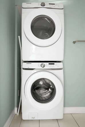 A Samsung front-loading washer and dryer stacked vertically in a laundry room. - Charming Second Floor Condo 6 Blocks To King (Charleston)