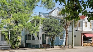 A two-story building with a porch and a staircase leading to the second floor.