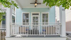 A porch with a white railing, a ceiling fan, and a light fixture. - Rooftop Patio, Unparalleled Views in 3-story Home (Charleston)