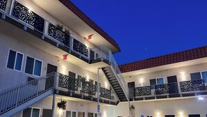 A multi-story hotel with balconies, a parking area, and a sign indicating a handicapped accessible room. - Newer private apart-hotel suite in Old Town (San Diego)