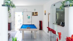 A pool table in a room with white walls and a tiled floor, surrounded by potted plants and a red chair. - Villa Salines (sleeps 15) Sainte-Anne Jacuzzi Pool, 5 minutes from Pointe Marin (Sainte-Anne)