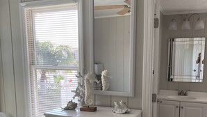 Un dormitorio con cama, cómoda y ventana con persianas.