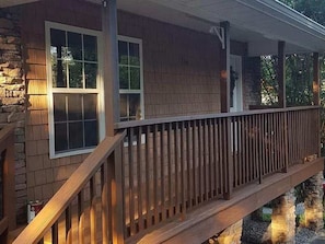 A house with a wooden deck and a stone foundation. - The Southern Comfort (Pigeon Forge)