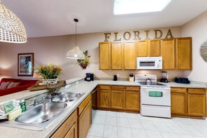 Enjoy cooking in this well-equipped kitchen with a central island, sink, and stove.