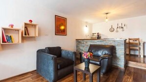 Een moderne woonkamer met een bank, een salontafel en een accentmuur van steen.