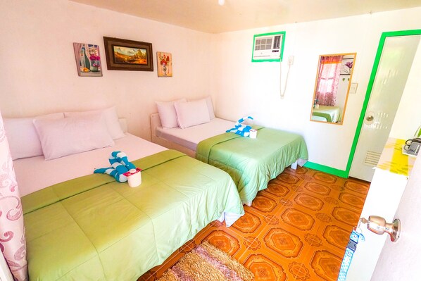 Een kamer met twee bedden, een kleurenstelsel van groen en wit, een patroon vloer en een deur met spiegel.