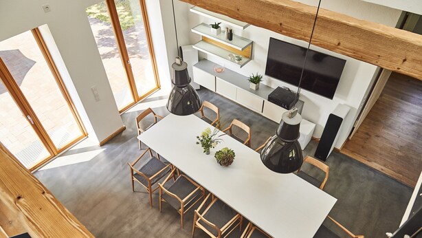 Una cocina moderna con una isla grande, sillas de madera y una mesa de comedor.