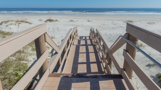 A wooden boardwalk leading to a beach with sand dunes and the ocean in the background. - Great St. Augustine beach vacation rental at a family friendly price! (Saint Augustine)